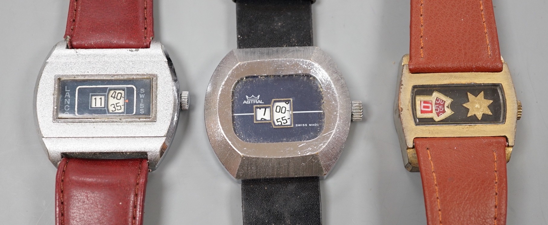 Three assorted steel or gilt steel jump hour digital manual wind wrist watches, including Astral and Lanco.